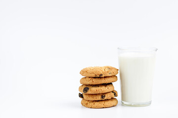 A glass of milk and cookies with raisins on a white background
