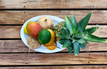 Top-view of a plate of fresh tropical fruits on a wooden table
