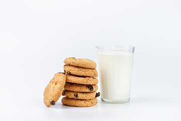 A glass of milk and cookies with raisins on a white background