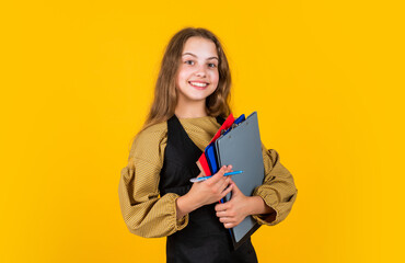 stylish child girl working with paper documents in folder, back to school