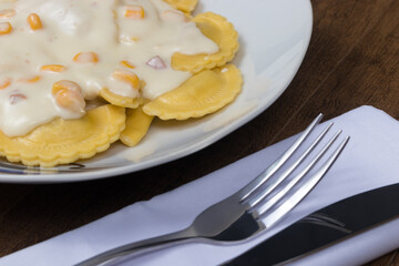 Ravioli with white sauce. Close-up photograph of Italian cuisine. Food widely consumed also in Brazil