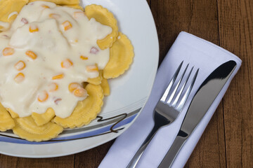 Tasty chicken Ravioli with white sauce made with corn. Top view photography