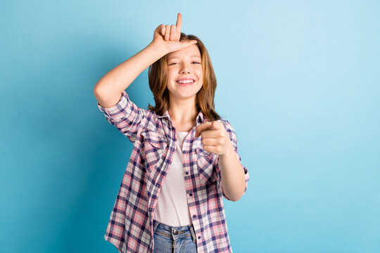 Photo of rude bully small girl wear checkered shirt pointing finger you showing loser sign isolated blue color background