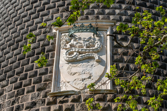 Details of the Sforza Castle (Castello Sforzesco) with the coat of arms of the Visconti noble family with a snake that swallows a human (Biscione). Milan, Italy.