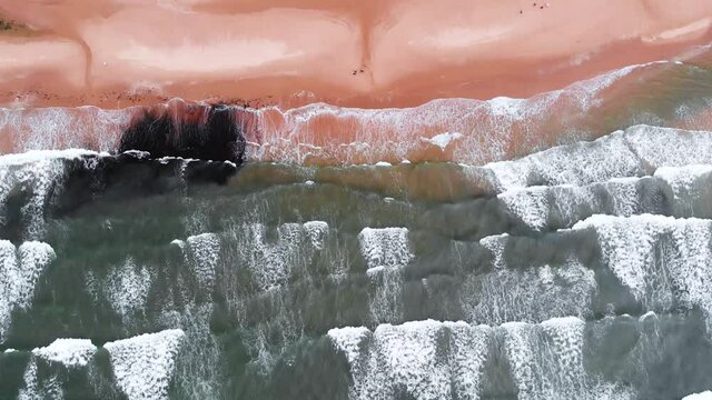 Straight Down Drone Shot Of Rhossili Bay and Rhossili Beach in The Gower Peninsula, Wales. Showing Rolling Waves Crashing Onto The Beach