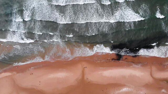Straight Down Drone Shot Of Waves Rolling Waves Crashing Onto Rhossili Beach in The Gower Peninsula, Llangennith Wales.