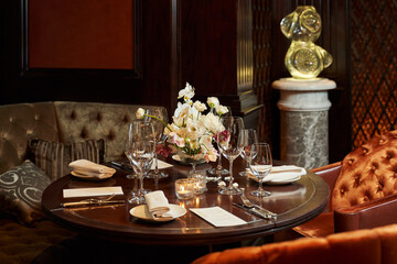 table in a restaurant with a dark interior. soft sofas stand around the table