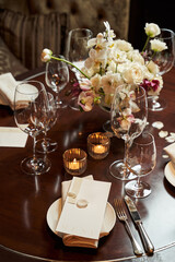 festive table setting in a restaurant with white petals and a beautiful white bouquet