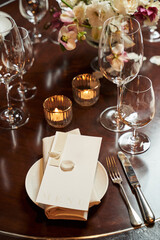 white plate with napkin and menu. transparent glasses