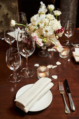 solemn table setting with a white flower arrangement in the center of the table