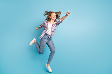 Full size profile portrait of carefree cheerful pupil raise fist look empty space isolated on blue color background