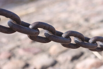 Heavy cast iron chain with rust. Protective fence on the bank of the Neva River in St. Petersburg.