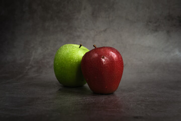 green and red apple on dark background