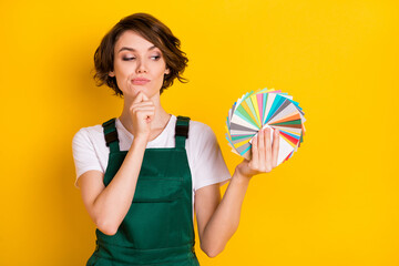 Photo of happy good mood lovely pretty woman paint thinking about color choice isolated on yellow...