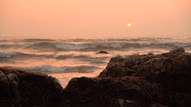Beautiful view sunset over the sea, ocean waves crashing on the beach shore