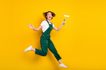 Full size photo of happy smiling good mood funky girl painter jumping wear uniform overall isolated...