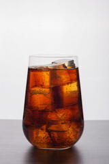 Glass of cola with ice cubes with fizzy bubbles.Vertical orientation.