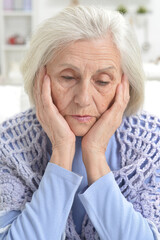 Close up portrait of sad senior woman with headache