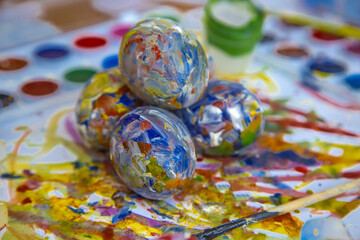 Easter colored eggs lie together in two rows of colorful background, paint is visible on the sides. Bright Easter eggs. Eggs decorated with paint. Multicolored eggs for Easter.