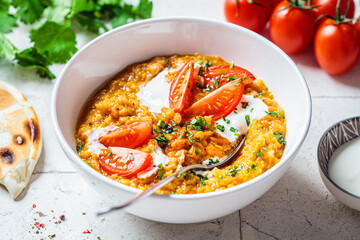 Vegan lentil soup with cilantro and tomato. Dal soup with tomatoes. Indian cuisine concept.