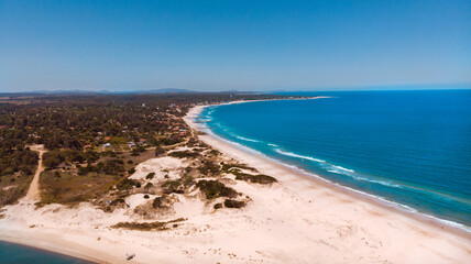 Beautiful view of the clear blue skies over the ocean and the sand in  Canelones, Uruguay