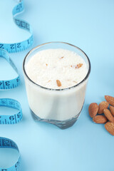  measurement tape almond nut and milk on blue background 