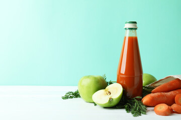 Bottle of juice and ingredients against mint background