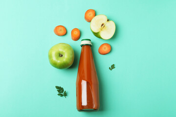 Bottle of juice and ingredients on mint background
