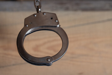 Handcuffs on brown background background isolate