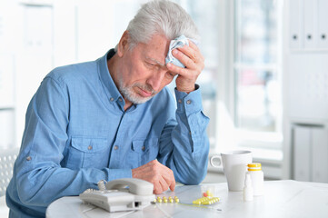 Portrait of sad sick senior man with medicine