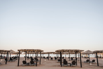 Beautiful lounge pavilion canopy for relax on the beach with sand and sea side view and blue sky. Luxury summer vacation in tropical paradise resort hotel