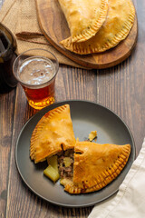 British famous cornish pasty, with beef, carrot, and potato on wooden background.