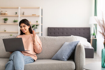 Woman having video call using laptop and talking