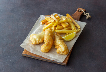 Fish and chips on a dark background. British fast food. Recipes. Snack to beer. English cuisine.