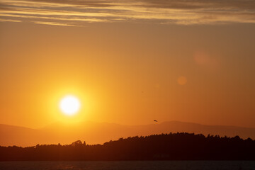 Dramatic sunrise landscape at Urla, Izmir, Turkey. Beautiful blazing sunrise landscape over bright blue sea and orange cloudy sky
