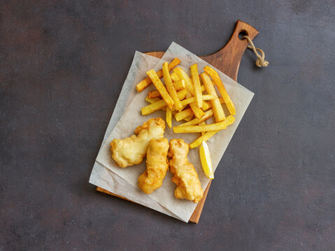 Fish and chips on a dark background. British fast food. Recipes. Snack to beer. English cuisine.