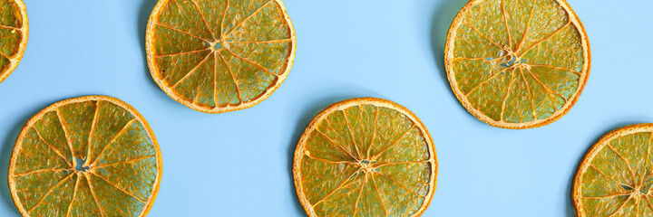 bright round sliced pieces of dried jerky oranges on a contrasting blue background, repeating...