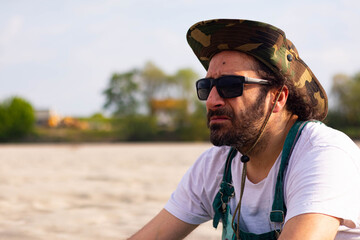 Hippy man with hat beard and glasses at the beach outdoors