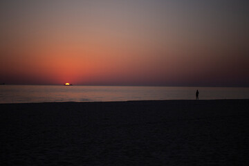Fototapeta premium orange sunrise at sea with the silhouette of the container ship