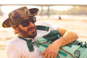 Hippy man with hat beard and glasses at the beach outdoors