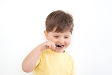 Happy kid raised a spoon to his mouth