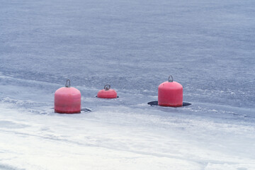 red buoys on the background of melting snow in spring, minimalistic landscape