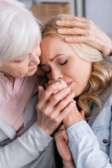 Senior woman hugging and calming upset daughter