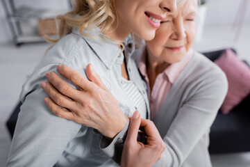Fototapeta premium Blurred senior woman hugging smiling daughter