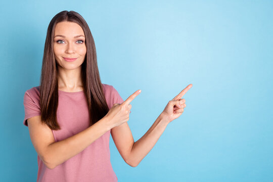 Photo of young charming attractive young woman point fingers empty space promo isolated on blue color background