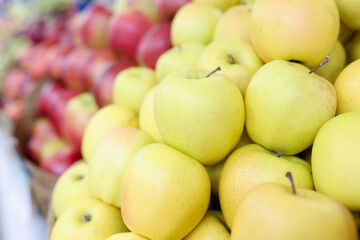 Many yellow and red apples lying in shop window closeup