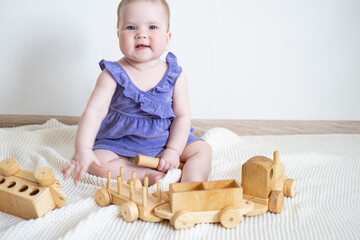 Little cute Baby girl playing with wooden train