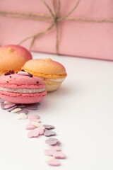 Obraz na płótnie Canvas multicolored dessert macarons on a white background decorated with delicate candy hearts