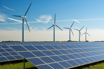 Wind turbine energy generators on wind farm, with solar panels underneath.