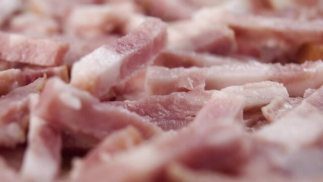 Chopped bacon falls into a heap in slow motion. Macro shot. Dolly Shooting